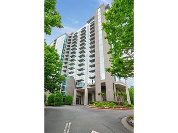 Modern high-rise condo building featuring balconies and landscaped entrance at 3300 Windy Ridge Se Pkwy # 1212, Atlanta, GA 30339