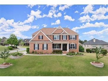 Beautiful two-story brick home with a manicured lawn and colorful flowerbeds at 4605 Heathcliff Way, Cumming, GA 30041