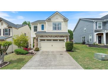 Charming two-story home with stone accents and well-manicured landscaping at 6065 Falls Landing Dr, Cumming, GA 30040