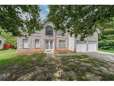 Charming two-story brick home featuring an attached two car garage at 1528 Rogers Crossing Dr, Lithonia, GA 30058
