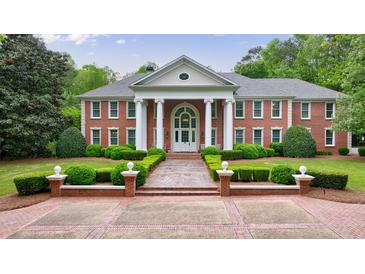 Stately brick home featuring manicured landscaping and a columned entrance at 4500 Candacraig, Alpharetta, GA 30022
