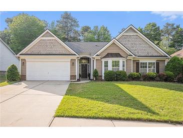 Charming home featuring a well-manicured lawn, attached garage, and inviting curb appeal at 352 Southgate Dr, Locust Grove, GA 30248