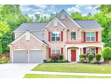 Charming two-story brick home with a well-manicured lawn and two-car garage at 5008 Bethpage Dr, Suwanee, GA 30024