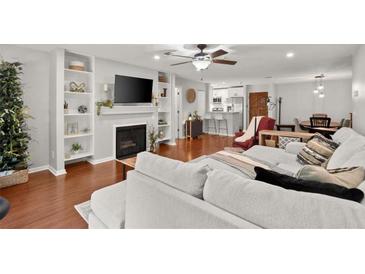 Open-concept living room featuring hardwood floors, a fireplace, built-in shelves, and neutral decor at 305 Ridley Howard Ct, Decatur, GA 30030