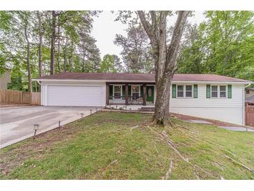 Charming single-story home featuring a lush front yard, attached two-car garage, and inviting front porch at 4100 Springlake Cir, Buford, GA 30519