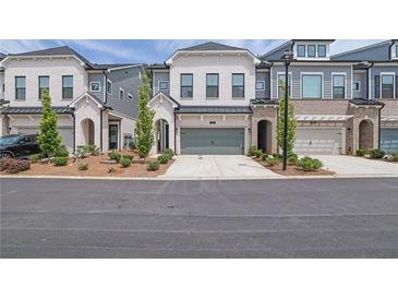 Charming townhome featuring a two-car garage and a beautifully landscaped front yard at 1110 Harper Dr, Roswell, GA 30076