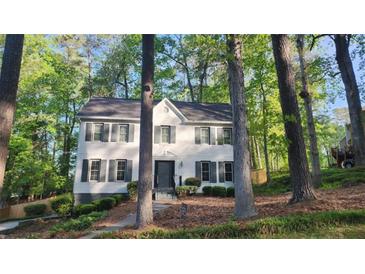 Charming white two-story home with black shutters surrounded by lush trees at 1508 Walker Ridge Sw Dr, Marietta, GA 30064