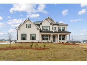 Charming two-story brick home with a welcoming front porch and lush green lawn at 321 Arwen Dr, Mcdonough, GA 30252