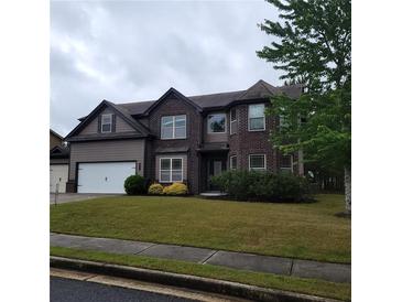 Inviting two-story home with a well-manicured lawn and a two-car garage, complemented by mature landscaping at 1474 Union Station, Lawrenceville, GA 30045