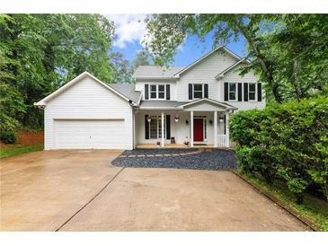 Charming two-story home with white siding, black shutters, red front door, and a well-manicured lawn at 1620 Bluewater Ct, Cumming, GA 30041