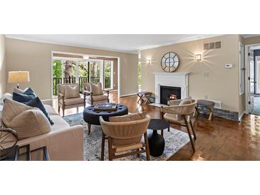 Bright living room with hardwood floors, fireplace, and access to a balcony provides elegant living space at 28305 Plantation Ne Dr, Atlanta, GA 30324