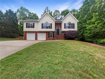 Charming two-story home featuring a two-car garage and a well-manicured front lawn at 541 Mckenzie Ave, Stockbridge, GA 30281