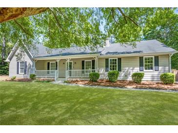 Charming single-story home with a welcoming front porch, lush green lawn, and mature trees providing shade at 45 Pine Tree Dr, Mcdonough, GA 30252