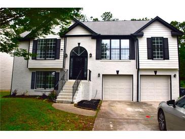 Charming two-story home featuring a well-manicured lawn and a two-car garage at 3211 Oaktree Park Dr, Lawrenceville, GA 30044