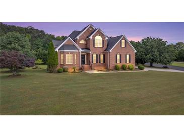 Beautiful two-story brick home with a manicured lawn and mature trees at 400 Kyle Ct, Fayetteville, GA 30215