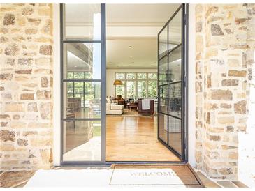Elegant entryway with steel frame glass doors, stone walls, and a glimpse of the inviting interior at 4785 Brinkley Ln, Atlanta, GA 30342