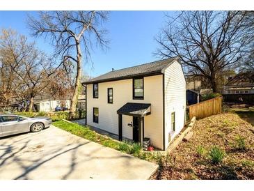 Charming two-story home with a well-manicured lawn and a driveway at 1051 Curran Nw St, Atlanta, GA 30318