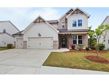 Charming two-story home boasts a three-car garage and well-manicured front yard at 2436 Hidden Creek Road, Kennesaw, GA 30152