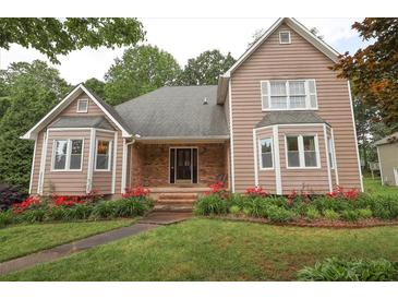 Charming two-story home featuring a well-maintained lawn and landscaped garden with vibrant red flowers at 5665 Stewart Woods Dr, Douglasville, GA 30135