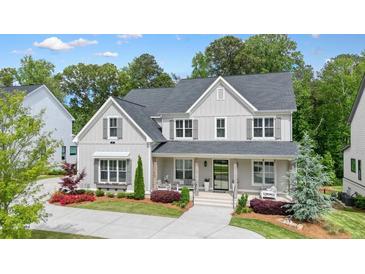 Charming two-story home with gray siding, dark shutters, a welcoming front porch, and beautifully landscaped front yard at 107 Owens Mill Place, Canton, GA 30115