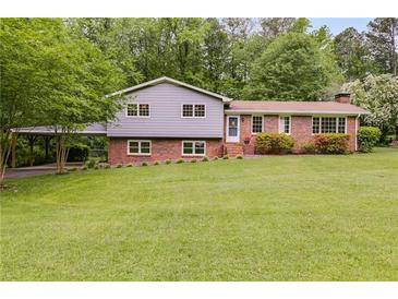 Charming two-story home with brick accents, a well-manicured lawn, and mature trees at 385 Vineyard Nw Dr, Marietta, GA 30064