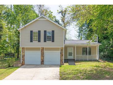 Charming two-story home with a covered porch, a two-car garage, and a well-manicured front lawn at 1147 Williamsburg Ln, Norcross, GA 30093