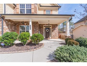 Inviting brick front porch with well-manicured landscaping, columns, and a charming front door at 965 Mulberry Bay Dr, Dacula, GA 30019