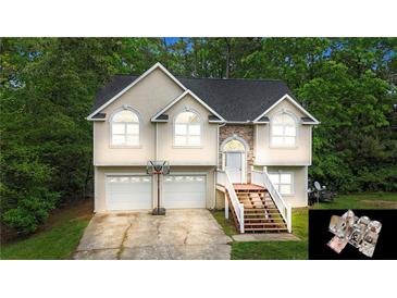 Charming two-story home with two-car garage, landscaped yard, and inviting front entrance, nestled among mature trees at 59 Abbotsford Dr, Villa Rica, GA 30180