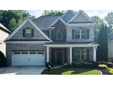 Charming two-story home featuring a brick facade, manicured lawn, and welcoming front porch at 2376 Roberts View Trail, Buford, GA 30519