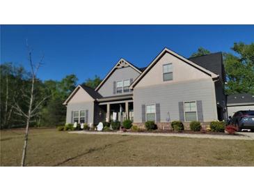 Charming two-story home with neutral siding, black roof, lush landscaping, and a welcoming covered front porch at 101 Ruby Lane, Mcdonough, GA 30252