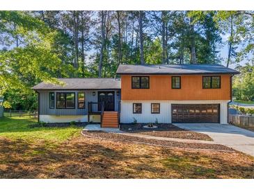 A charming two-story home featuring a two-car garage and gray and wood-paneled facade at 1129 Pinehurst Rd, Grayson, GA 30017