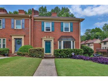 Charming brick townhouse with teal shutters, tidy landscaping, and inviting entryway at 6139 Keswick Row, Tucker, GA 30084