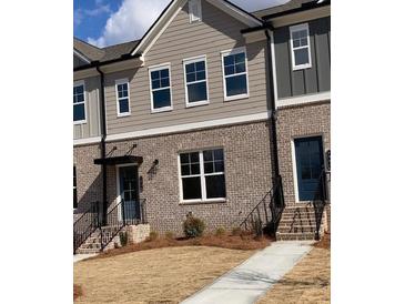 Charming townhome with brick facade, covered entry, and landscaped front yard at 1258 Ainsworth Aly # 46, Sugar Hill, GA 30518