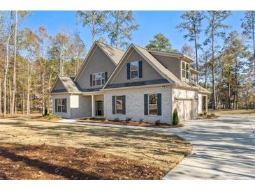 Beautiful two-story home featuring a painted brick facade, well-manicured lawn, and a seamlessly attached two-car garage at 1874 Mcgarity Rd, Mcdonough, GA 30252