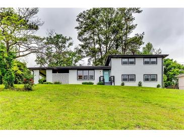 Charming two-story white brick home with a bright teal front door and a well-manicured front yard at 2932 Valley Ridge Dr, Decatur, GA 30032