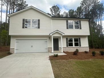 Charming two-story home with a white garage, siding, and a well-manicured lawn at 35 Yellow Brick Way, Covington, GA 30014
