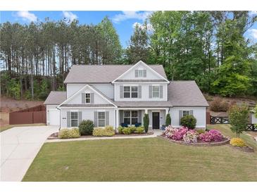 Charming two-story home with landscaped yard, lush green lawn and beautiful flowering shrubs in the flower beds at 124 Grand Oaks Dr, Canton, GA 30115