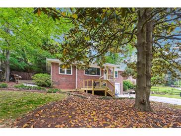 Charming brick home featuring a wood deck, lush landscaping, and mature trees, providing great curb appeal at 2771 Stonecreek Se Rd, Smyrna, GA 30080