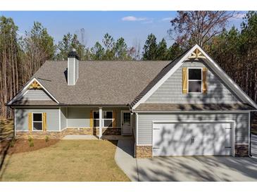 Charming single-Gathering home featuring a two-car garage, stone accents, a gabled roof, and lush greenery at Lot 1 Perkins Rd, Dallas, GA 30157