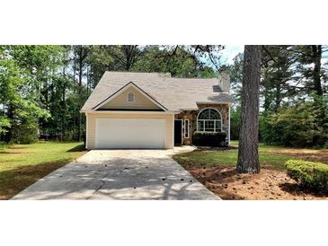 Charming single-Gathering home with stone accents, a two-car garage and a well-maintained lawn at 60 Whispering Pine Ct, Covington, GA 30016