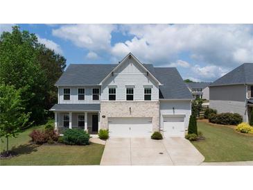Charming two-story home with a well-manicured front yard, three car garage, and appealing architectural details at 3985 Starwood Dr, Cumming, GA 30028