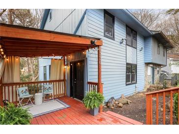 Charming two-story home with light blue siding and a cozy red porch under a string-lit pergola at 1350 Overlook Se Cv, Smyrna, GA 30080