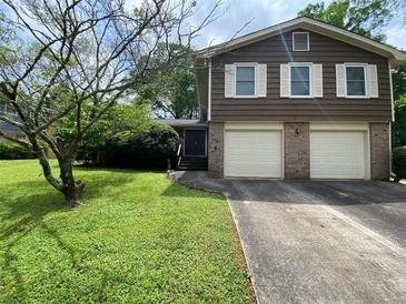 Charming split-level home with a two-car garage and well-maintained front lawn at 4457 Huntshire Dr, Stone Mountain, GA 30083