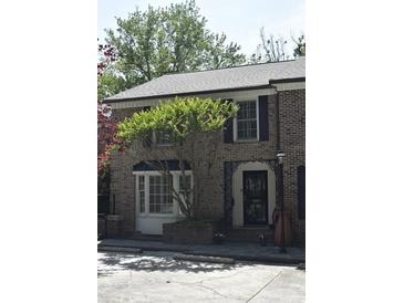 Charming brick home featuring a bay window, black shutters, and an ornamental iron front door gate at 11 Ardmore Nw Sq, Atlanta, GA 30309