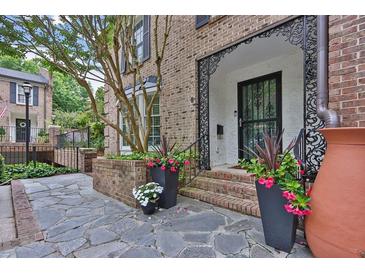 Inviting brick home entrance featuring a stone walkway, potted plants, and a decorative wrought iron porch at 11 Ardmore Nw Sq, Atlanta, GA 30309