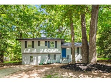 Charming split-level home with freshly painted brick, new landscaping, and a bright blue front door at 271 Leafwood Ln, Riverdale, GA 30274