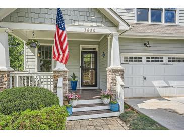 Charming front porch with stone pillars, American flag, and a well-manicured garden at 2686 Oak Leaf Se Pl, Atlanta, GA 30316