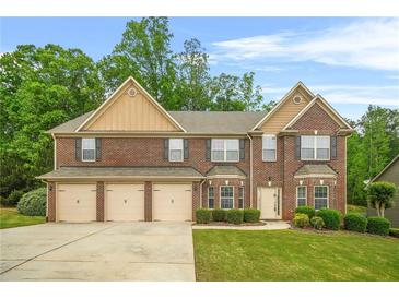 Charming brick two-story home boasts a three-car garage, manicured lawn, and lush landscaping at 4616 Town Manor Dr, Douglasville, GA 30135