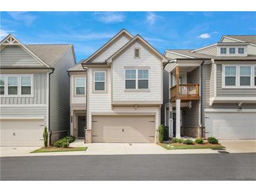 Charming two-story townhome with a two-car garage and manicured landscaping, complemented by a well-maintained facade at 354 Hayden Cir, Woodstock, GA 30189