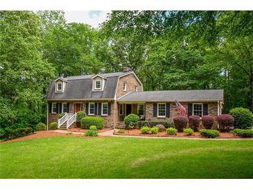 Charming brick home with lush landscaping, manicured lawn and dormer windows at 110 Sandy Ridge Trl, Fayetteville, GA 30214